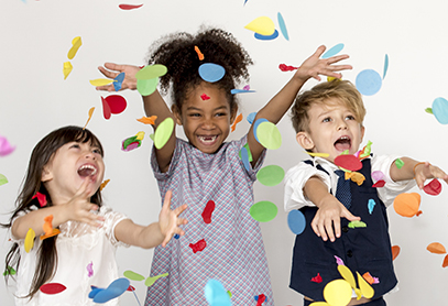 Three children playing in confetti